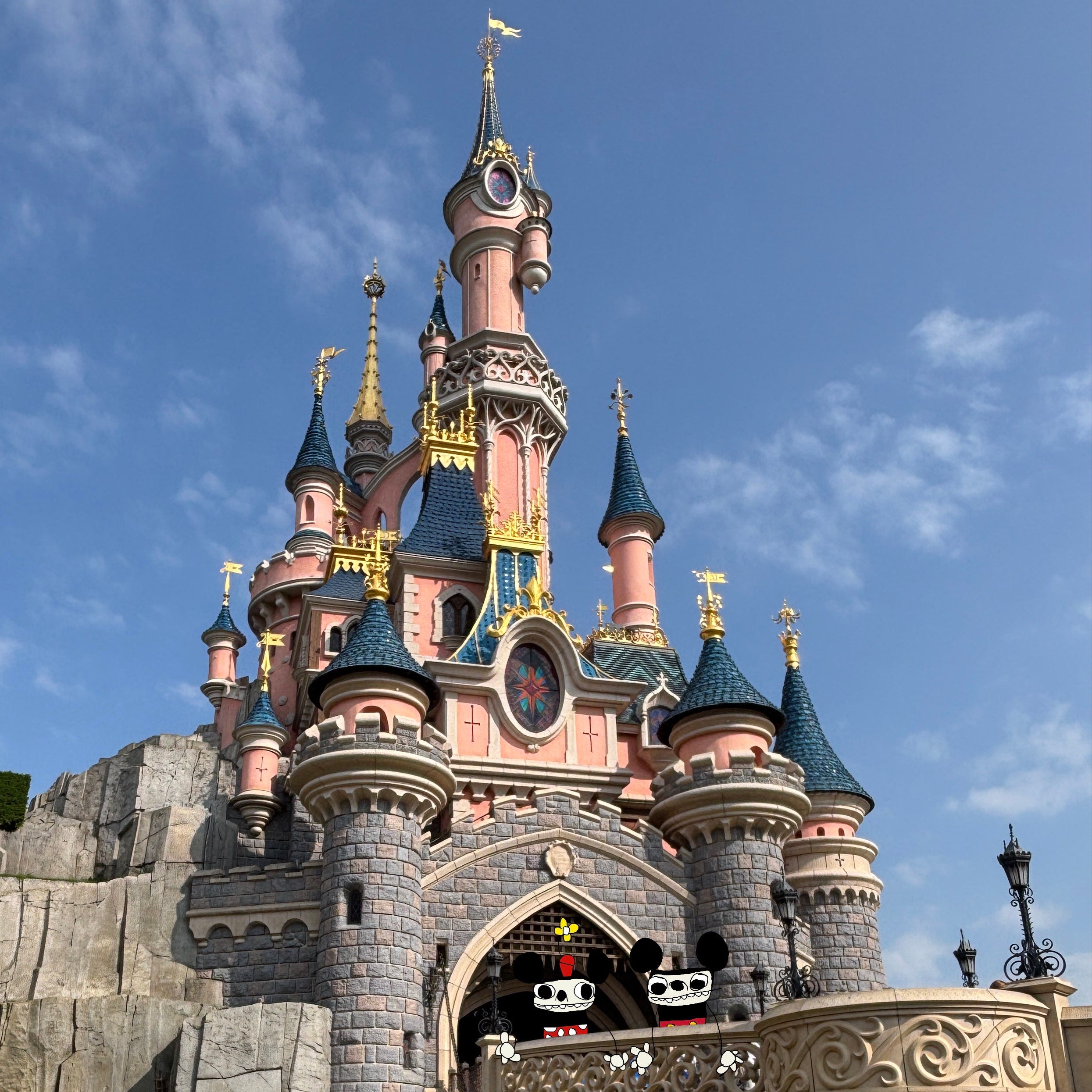 Disney castle with a person standing in front, under a blue sky